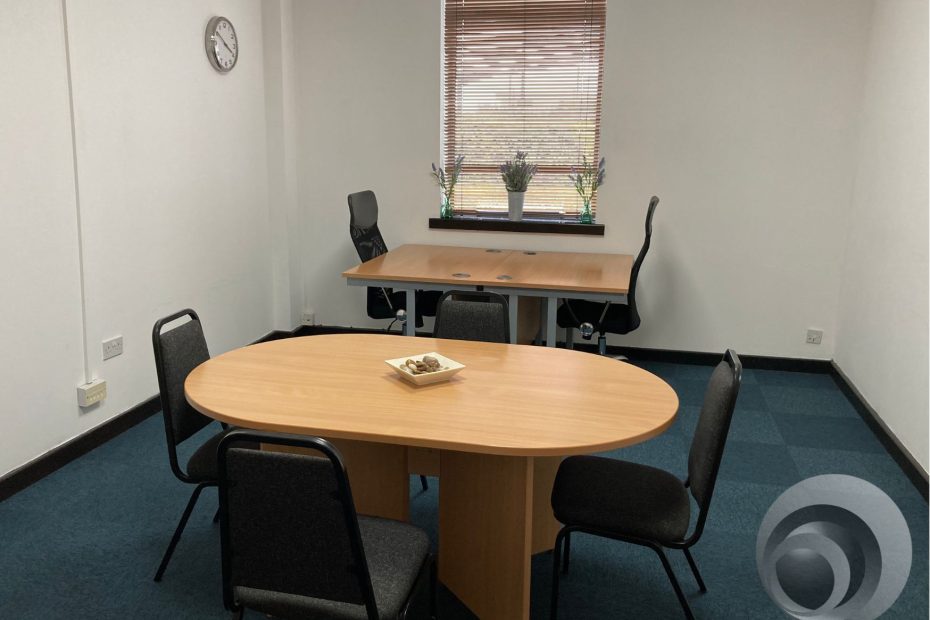 A professional yet relaxed office environment with a blend of workstations, private offices, and open seating areas. Employees can be seen working in flexible settings—some collaborating in meeting rooms, while others work individually in quiet spaces. The image highlights the adaptable and balanced nature of a serviced office that supports Hybrid Work Models.