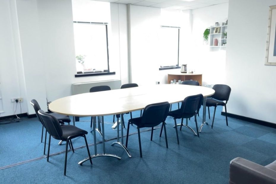 A professional, modern meeting room with large windows, well-spaced seating around a conference table, and technology setup including presentation screen and video conferencing system is available, capturing the essence of a polished and flexible meeting spaces.