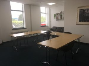 Professional meeting room setup with large windows, whiteboard, and modern furniture. meeting room hire offers cost savings, flexible scheduling, and a professional environment for small businesses and startups