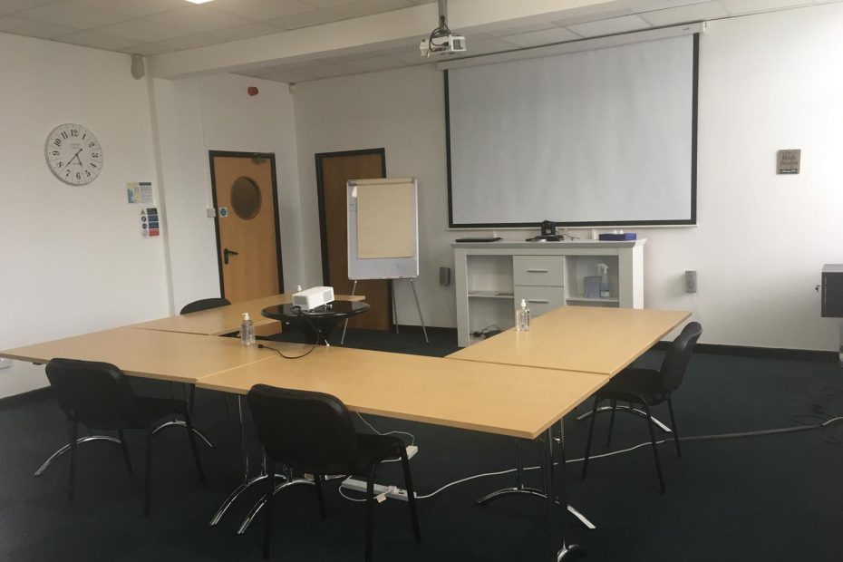 Professional meeting room with presentation screen, projector, and client seating. Creating first impressions that last.